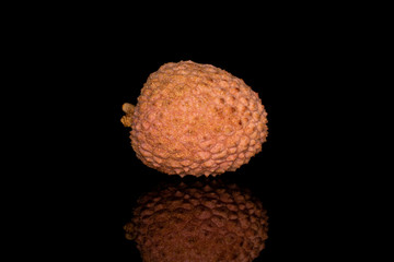 One whole fresh lychee isolated on black glass