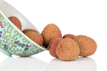 Lot of whole fresh lychee fruit with blue chinese ceramic bowl isolated on white background