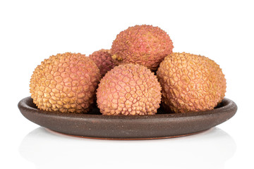 Group of five whole fresh lychee with brown ceramic coaster isolated on white background