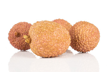 Group of four whole fresh lychee fruit isolated on white background