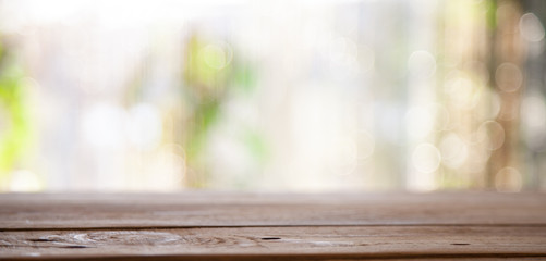 Top of wooden table on window glass blur. Of green from the garden of the vegetable garden on a...