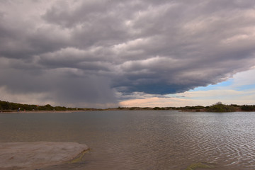Dark clouds in sunset over the lake