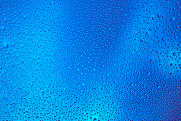 Drops of water on a glass with a color gradient.