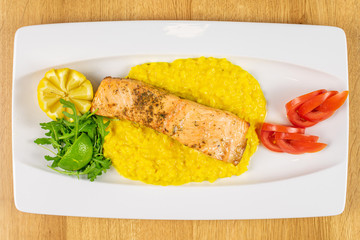 Beautiful grilled salmon with potato mash on white rectangular ceramic plate flatlay on lacquered wood