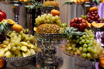 Fruits on wedding reception. Wedding banquet table. Sweet table with fruit, wedding catering, fruit bar on party
