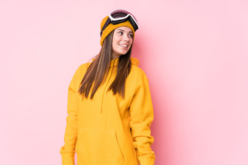 Young caucasian skier woman isolated looks aside smiling, cheerful and pleasant.