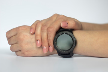 female hand with fashion manicure and smart watch on a white background