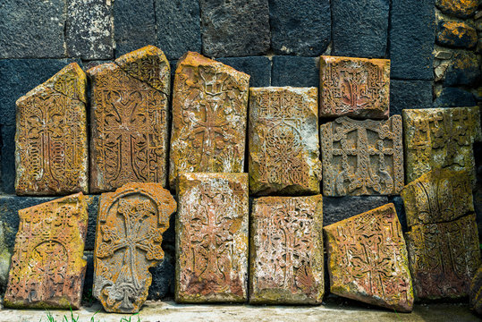 Close-up of ancient stone khachkars with carved lace patterns on the walls of a monastery in Armenia