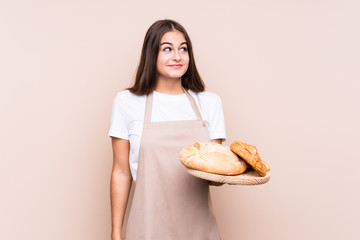 Young caucasian baker woman isolated dreaming of achieving goals and purposes