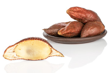 Group of four whole one half of exotic brown salak with brown ceramic coaster isolated on white background