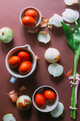 Dyeing eggs for Easter holidays, coloring with different color and tonality using natural food dye pigment and painting color, over a white  background, chocolate eggs , top view, flatlay,soft light