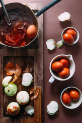 Dyeing eggs for Easter holidays, coloring with different color and tonality using natural food dye pigment and painting color, over a white  background, chocolate eggs , top view, flatlay,soft light