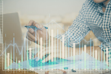 Multi exposure of forex graph with man working on computer on background. Concept of market...