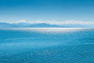 Lake Sevan in Armenia, sun glare on the water surface of the lake on a sunny day