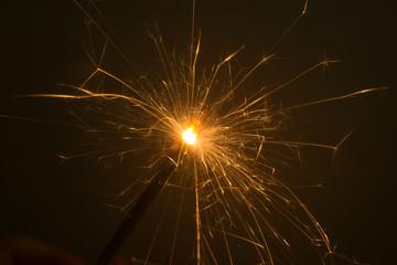 Obraz premium I hold a sparkler in my hand, which sparkles beautifully in different directions.