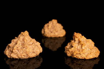 Group of three whole homemade brown coconut biscuit with chocolate isolated on black glass