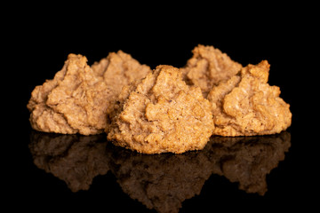 Group of five whole homemade brown coconut biscuit with chocolate isolated on black glass