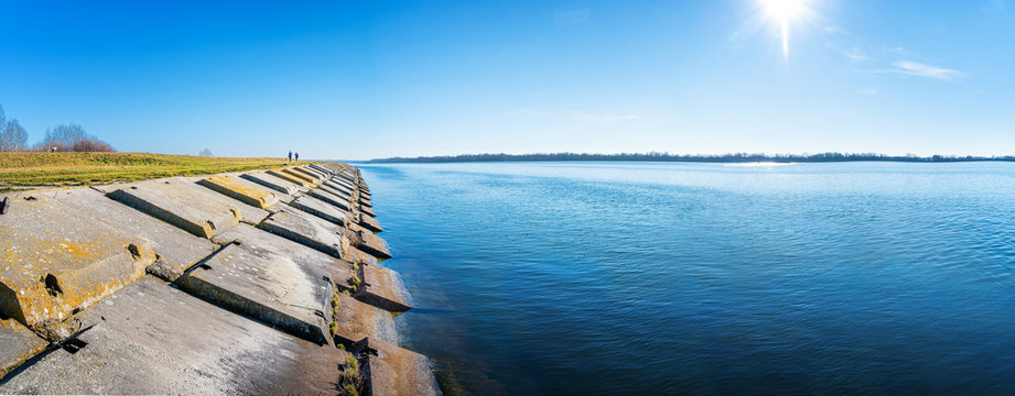 Gabcikovo Dam with bank made of concrete blocks on sunny day - panoramic