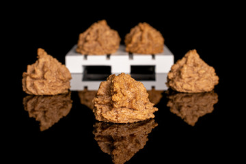 Group of seven whole homemade brown coconut biscuit with chocolate on white wooden pallet isolated on black glass