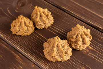 Group of four whole homemade brown coconut biscuit with chocolate on brown wood