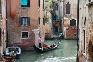 Fototapeta na wymiar A canal in Venice, Italy with a gondolier and boat