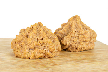 Group of two whole homemade brown coconut biscuit with chocolate on bamboo cutting board isolated on white background
