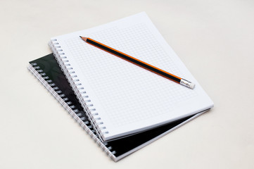 open school notebook with pencil on a beige background