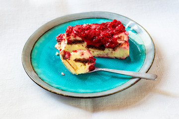 Red garden fruit cake on blue plate on white table.