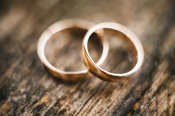 Obraz na płótnie Canvas Wedding rings on a beautiful wooden texture surface closeup