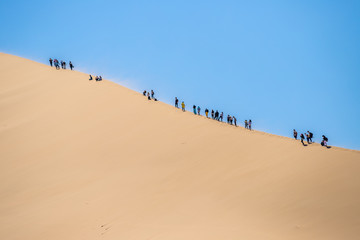 Fototapeta na wymiar climbing the dune. singing dune in kazakhstan