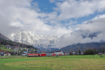 Fototapeta na wymiar Train passing by the small mountain village of Oblarn in the district of Liezen in Styria, Austria.