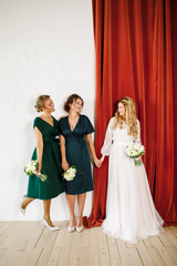 young beautiful blonde wedding bride in a beautiful white dress stands on a red background
