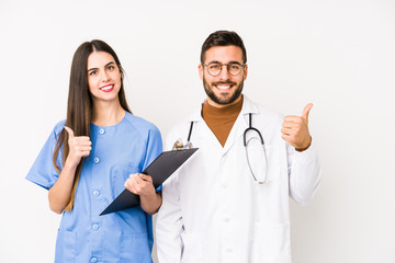 Young doctor man and a nurse isolated smiling and raising thumb up