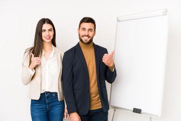 Young caucasian business couple isolated smiling and raising thumb up