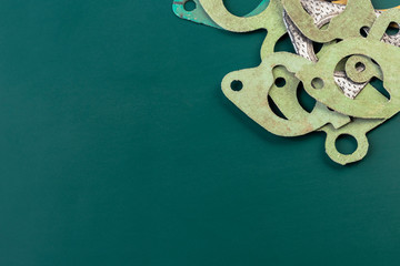 The graphic background is green. Gasket silencer, manifold, thermostat. Close-up. Copy space.