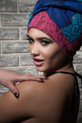 Portrait of a beautiful sexy brunette girl with bright makeup and oriental turban