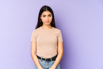 Young indian woman isolated on purple background sad, serious face, feeling miserable and displeased.