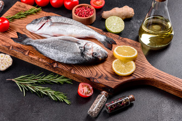 Raw dorado fish with spices cooking on cutting board. Fresh fish dorado
