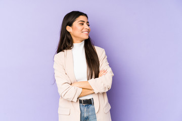 Young indian woman isolated on purple background smiling confident with crossed arms.