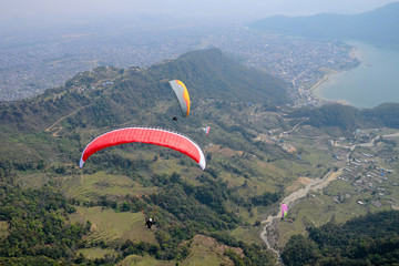 Paragliding in Nepal. Paragliders on the background of Phewa Lake and surrounding villages. Pokhara.