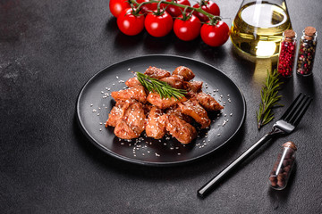 Chicken fillet in sesame seeds, teriyaki sauce on a black stone plate