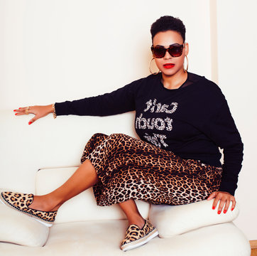 pretty stylish african american big mama woman well dressed. swag relax at home, leopard print on clothers. fashion look sunglasses
