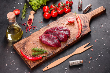 Fresh Raw Beef steak Mignon, with salt, peppercorns, thyme, tomatoes