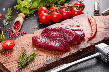 Fresh Raw Beef steak Mignon, with salt, peppercorns, thyme, tomatoes