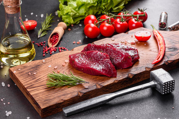 Fresh Raw Beef steak Mignon, with salt, peppercorns, thyme, tomatoes