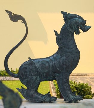 Bronze statue of a Singha guardian lion, one the many leogryphs (lion-like creatures) of asian and buddhist mythology. This one is located in Wat Benchamabophit temple, in Bangkok, Thailand.