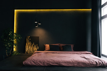 The interior of a modern apartment in black with yellow lighting. Beautiful interior decor