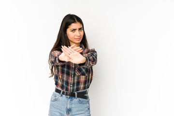 Young indian woman isolated on purple background standing with outstretched hand showing stop sign, preventing you.