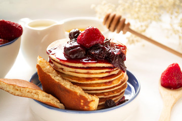 Pancakes for the celebration of Shrovetide with honey, jam and strawberries. Copy space.