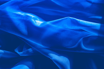 background image of a blue light translucent fabric with pleats. the view from the top.